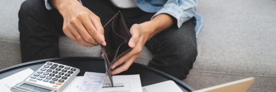 Man met rekenmachine en veel papieren