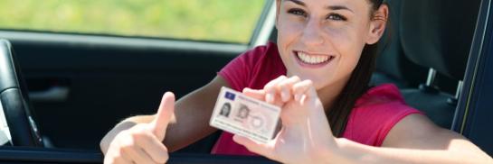Vrouw met rijbewijs in auto (bijgesneden)